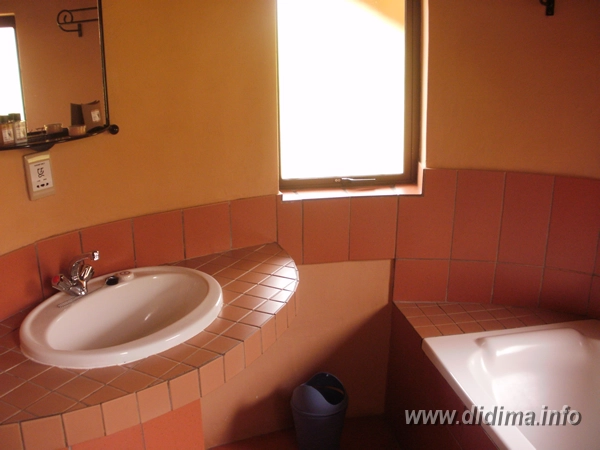 Private bathroom with bath and washbasin inside a four-sleeper Didima Camp chalet