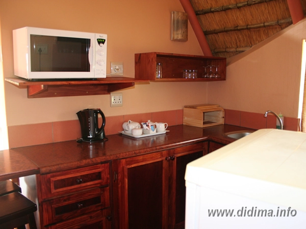 Kitchenette with microwave, kettle and fridge inside a four-sleeper interleading chalet