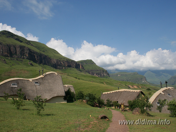 Thatched chalets and mountain scenery at Didima Camp in the Cathedral Peak valley